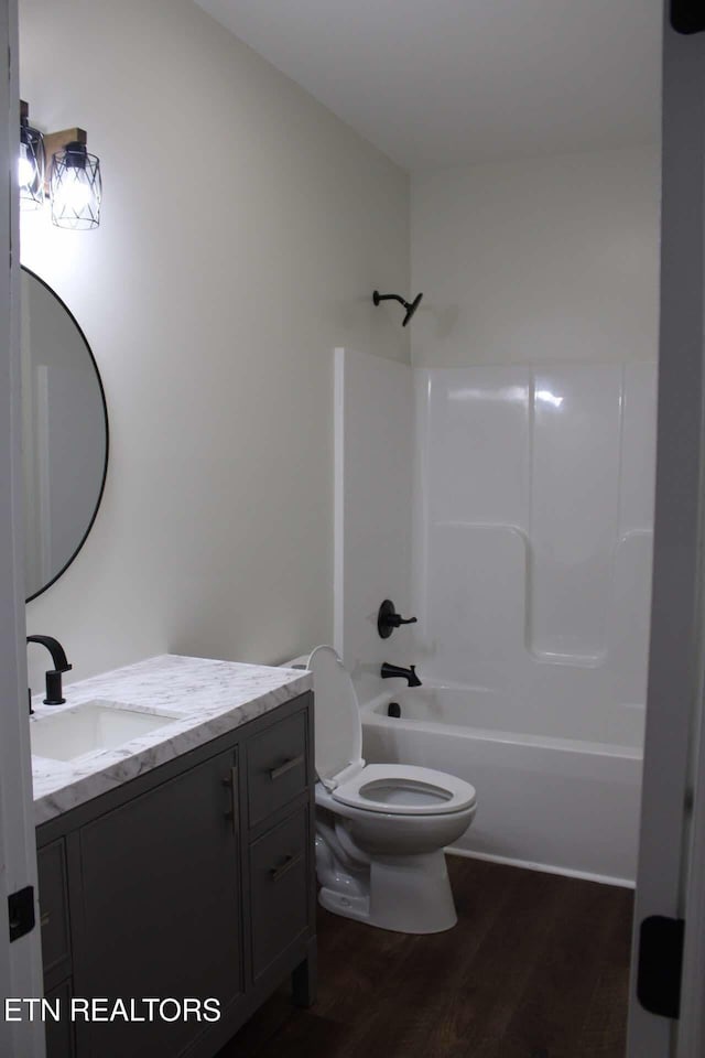 full bathroom featuring toilet, vanity, shower / bathtub combination, and hardwood / wood-style flooring