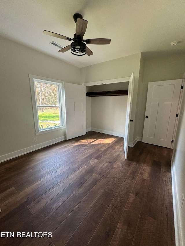 unfurnished bedroom featuring dark hardwood / wood-style flooring, a closet, and ceiling fan