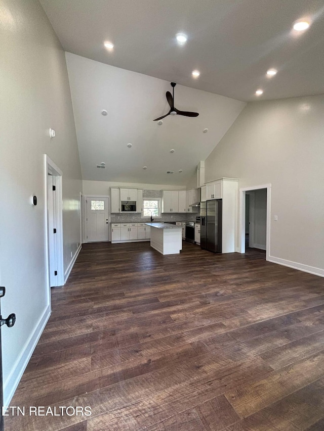 unfurnished living room featuring ceiling fan, high vaulted ceiling, and dark hardwood / wood-style floors