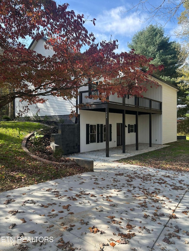 back of house featuring a deck and a patio