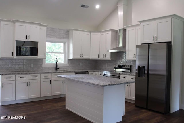 kitchen featuring white cabinets, appliances with stainless steel finishes, and wall chimney exhaust hood