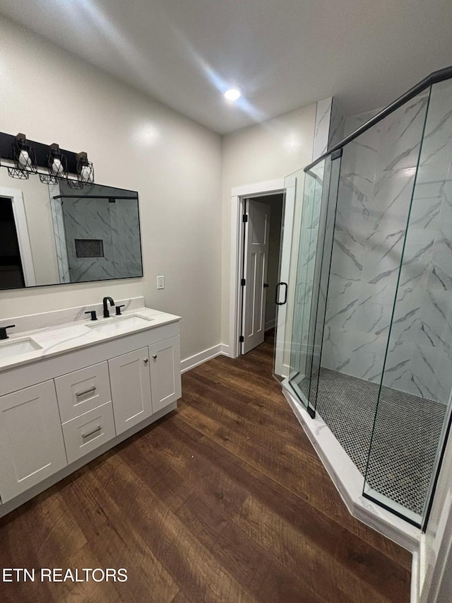 bathroom featuring hardwood / wood-style floors, vanity, and a shower with door