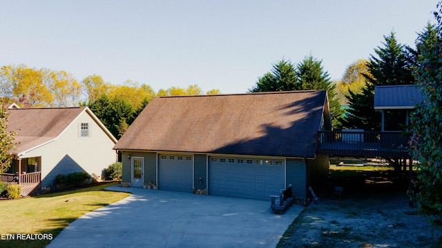 view of front of home with a garage, a front yard, and a deck