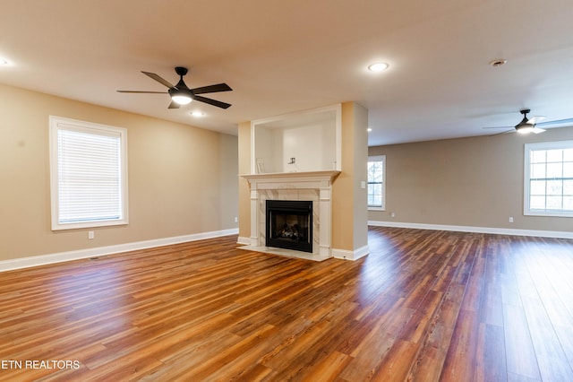 unfurnished living room with a fireplace, hardwood / wood-style floors, and ceiling fan