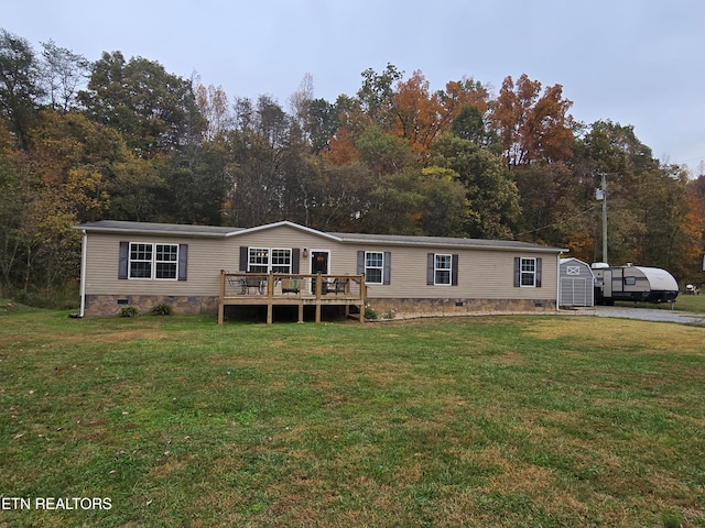 manufactured / mobile home featuring a front lawn and a wooden deck