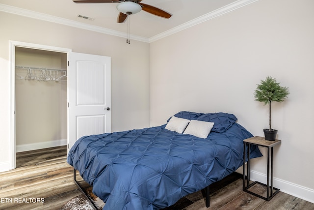 bedroom with wood-type flooring, a closet, ceiling fan, and crown molding