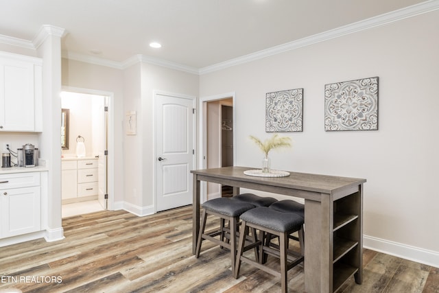 dining room featuring light hardwood / wood-style floors and ornamental molding