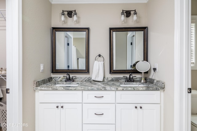 bathroom with vanity, toilet, and ornamental molding