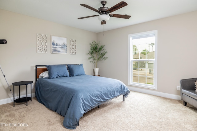 bedroom with ceiling fan and light colored carpet