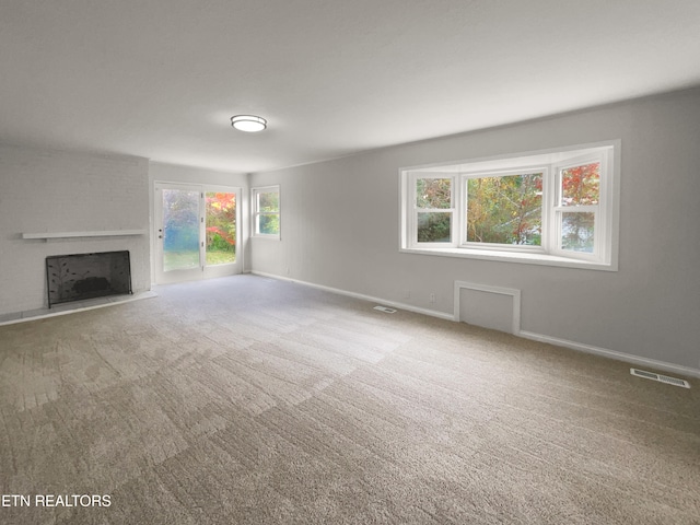 unfurnished living room with a fireplace and carpet floors