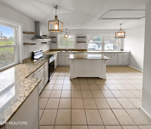 kitchen with a wealth of natural light, stainless steel range with electric cooktop, sink, and white cabinets