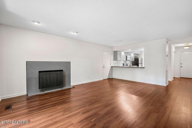 8709 Olde Colony Trl Unit 12, Knoxville, TN 37923 - unfurnished living room featuring wood finished floors, baseboards, and a fireplace with flush hearth