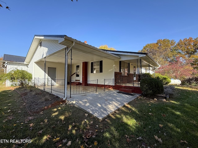 back of property featuring a porch and a lawn