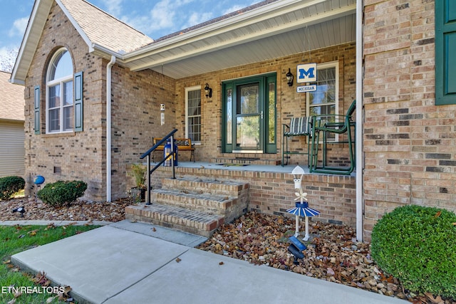 doorway to property featuring brick siding, crawl space, and a porch