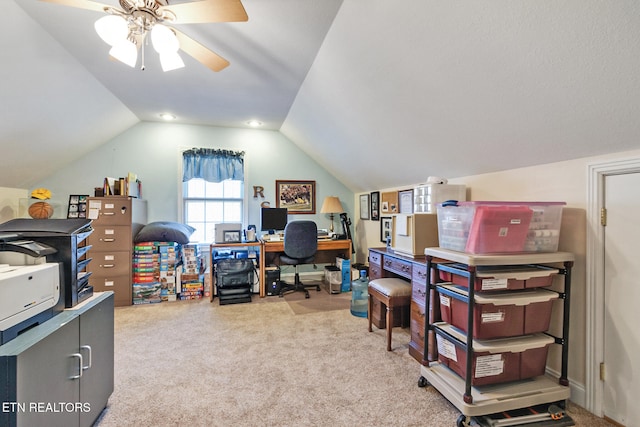 carpeted home office with lofted ceiling and a ceiling fan