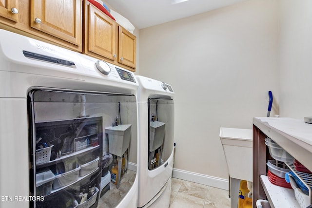 laundry room with washer and clothes dryer, cabinet space, and baseboards