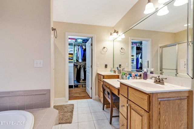 bathroom featuring a sink, a spacious closet, a shower stall, and tile patterned floors