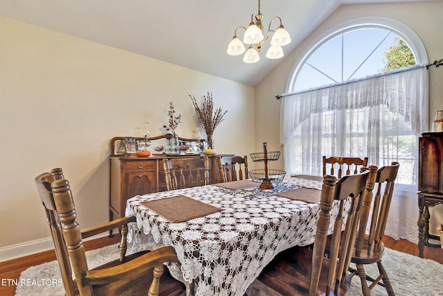 dining space with vaulted ceiling, baseboards, wood finished floors, and an inviting chandelier