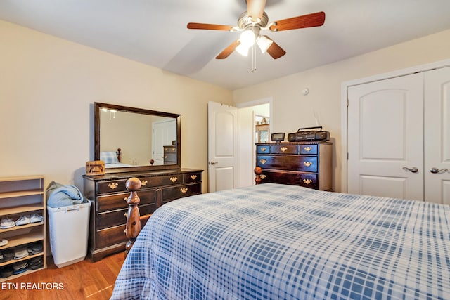 bedroom with a closet, light wood-type flooring, and a ceiling fan