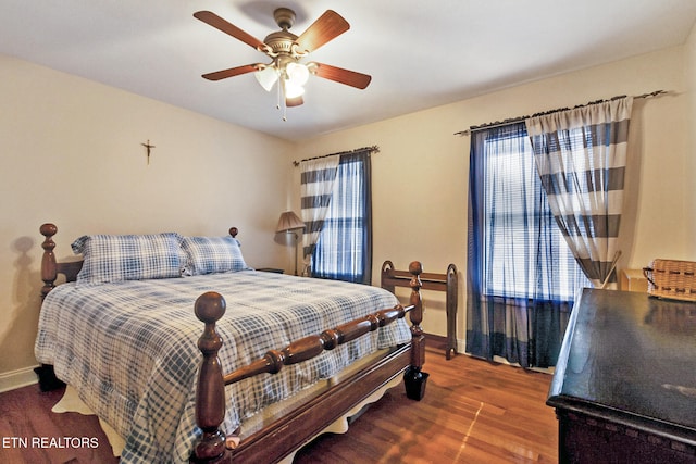 bedroom with ceiling fan, baseboards, and wood finished floors