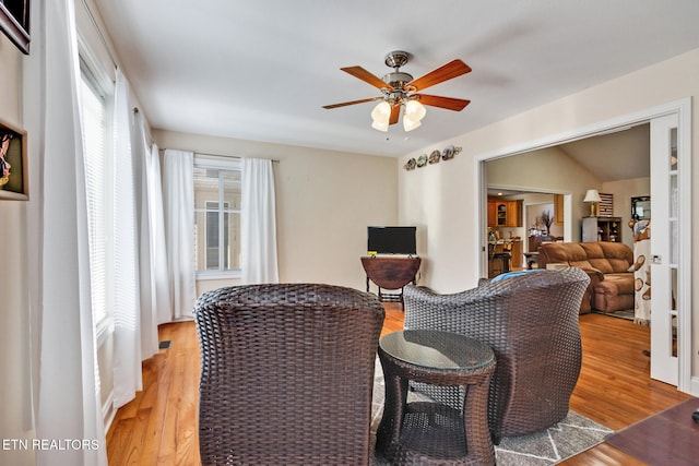 living area with light wood-type flooring and a ceiling fan