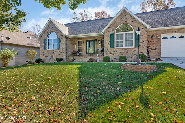 ranch-style home with a shingled roof, a front lawn, and brick siding