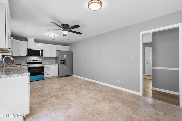 kitchen with appliances with stainless steel finishes, sink, white cabinets, and ceiling fan