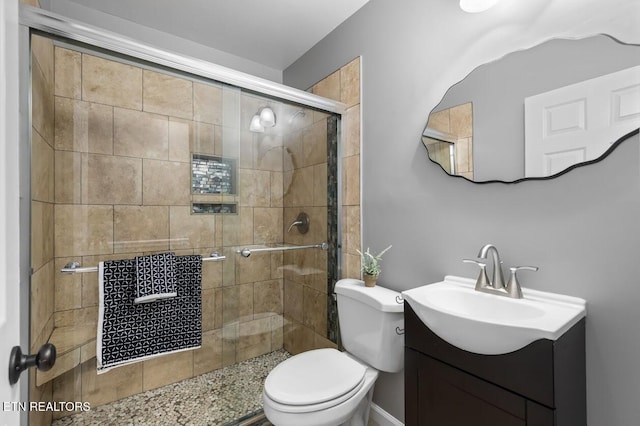 bathroom with vanity, toilet, and a shower with shower door