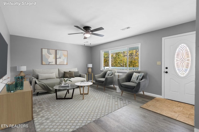 living room featuring wood-type flooring and ceiling fan