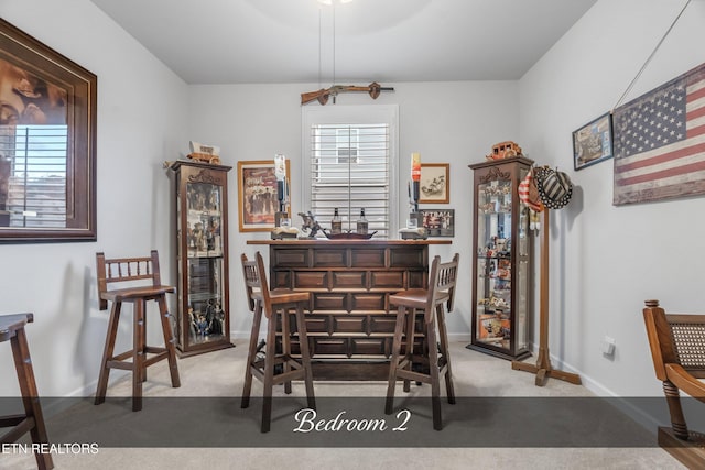 carpeted dining space with indoor bar