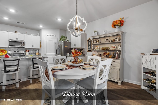 dining area featuring a chandelier and dark wood-type flooring