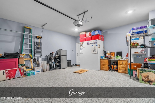 garage with white fridge, a garage door opener, and stainless steel fridge