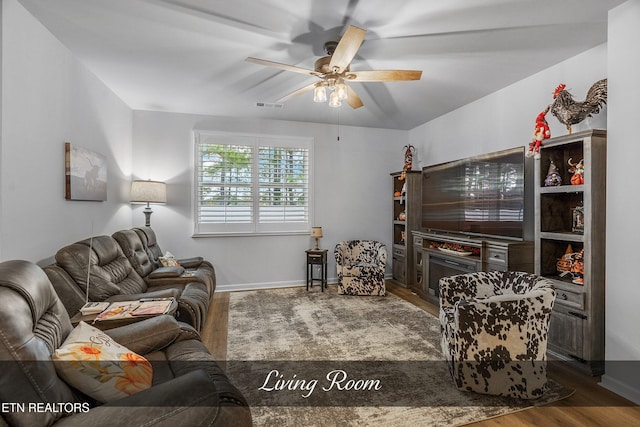 living room with dark wood-type flooring and ceiling fan