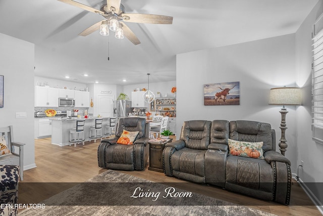 living room featuring light wood-type flooring and ceiling fan