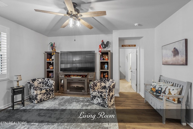 living room with dark wood-type flooring and ceiling fan