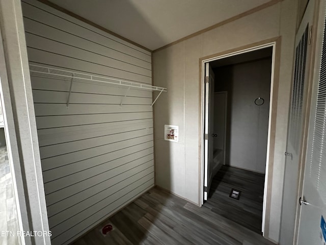 clothes washing area featuring wood-type flooring, washer hookup, and wood walls