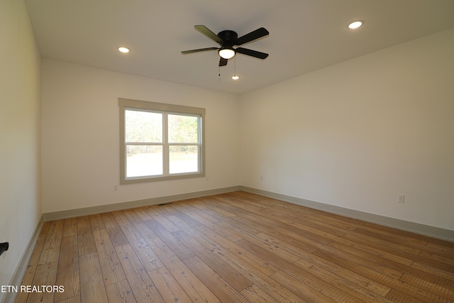 spare room featuring recessed lighting, baseboards, a ceiling fan, and light wood-style floors