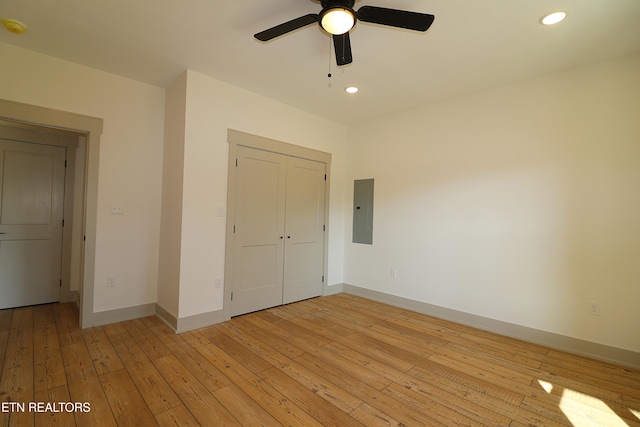 unfurnished bedroom featuring a closet, electric panel, light wood-type flooring, and ceiling fan