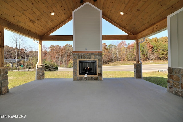 view of patio with a gazebo and an outdoor stone fireplace