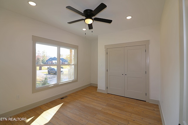unfurnished bedroom featuring baseboards, light wood finished floors, and visible vents