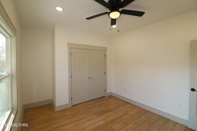 unfurnished bedroom featuring light wood-style floors, baseboards, a closet, and recessed lighting