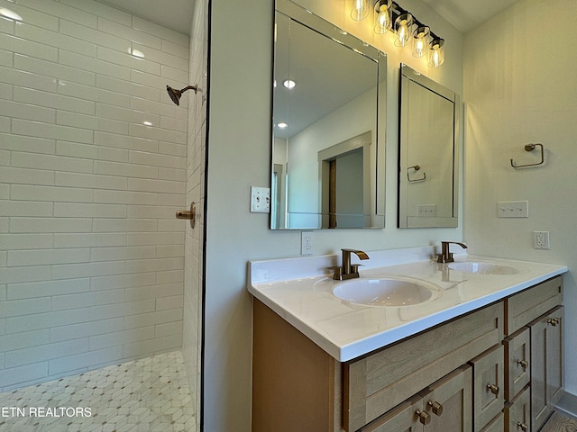 bathroom with a tile shower and vanity