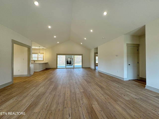 unfurnished living room featuring recessed lighting, baseboards, plenty of natural light, and light wood-style flooring