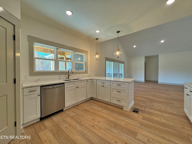 kitchen with sink, vaulted ceiling, stainless steel dishwasher, white cabinetry, and light hardwood / wood-style floors