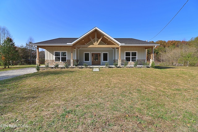 craftsman-style house featuring board and batten siding, a front yard, a porch, and stone siding