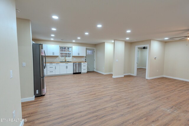 kitchen featuring stainless steel appliances, ceiling fan, sink, light hardwood / wood-style flooring, and white cabinetry