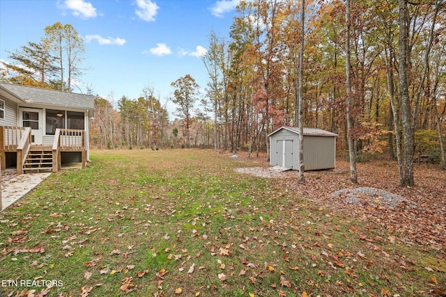 view of yard with a sunroom, a shed, and a wooden deck