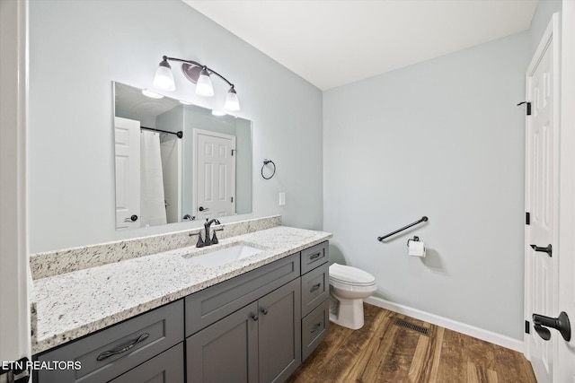 bathroom featuring hardwood / wood-style flooring, vanity, and toilet