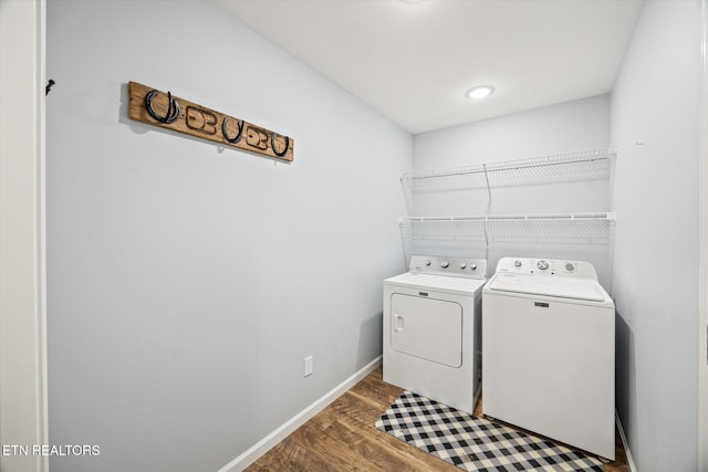 washroom with dark hardwood / wood-style flooring and washer and clothes dryer