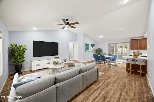 living room with wood-type flooring, ceiling fan, and lofted ceiling